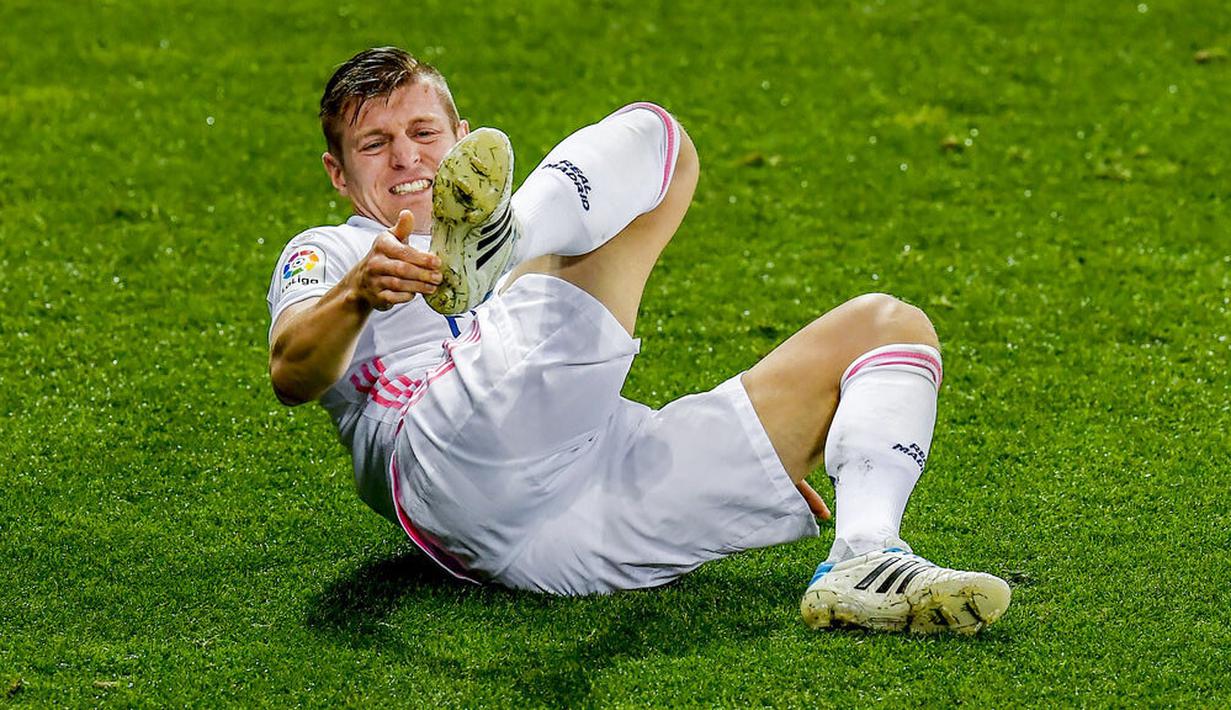 Gelandang Real Madrid, Toni Kroos, meringis kesakitan saat melawan Alaves pada laga Liga Spanyol di Stadion Mendizorroza, Sabtu (23/1/2021). Real Madrid menang dengan skor 4-1. (AP/Alvaro Barrientos)