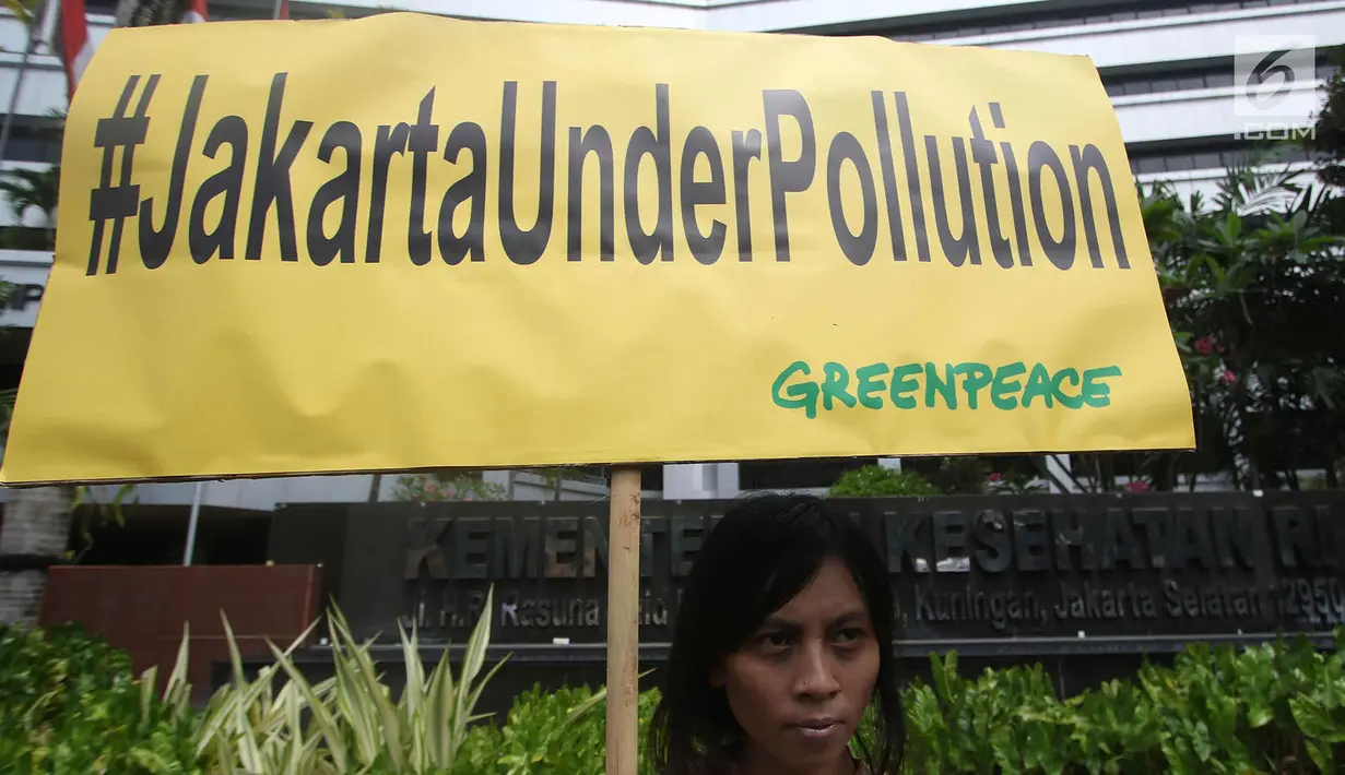 Aktivis Greenpeace berdiri membawa poster bertuliskan #JakartaUnderPollution saat melakukan aksi teatrikal di depan Kantor Kementerian Kesehatan, Jakarta, Kamis (28/9). (Liputan6.com/Immanuel Antonius)