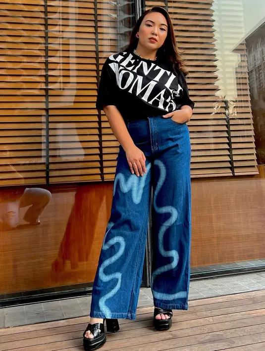 Perempuan berusia 30 tahun ini tampil dengan tshirt hitam Gentle Woman dipadukan celana denim bermotif.  [@angelicamanopo]