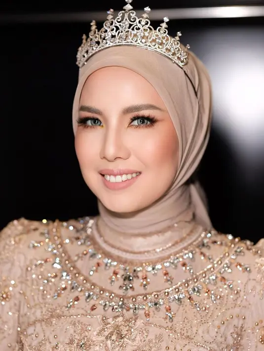 Tya Ariesta tampil tak kalah memukau. Dengan outfit cokelat yang dipenuhi batu dan payet berkilauan, Tya memadukan penampilannya dengan makeup bernuansa nude yang pas dan tiara yang mempermanis keseluruhannya. [Foto: Instagram/victoria_makeupatelier]