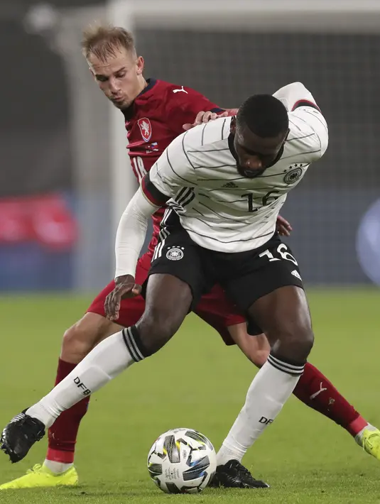 Penyerang Republik Ceko, Vaclav Cerny berebut bola dengan bek Jerman, Antonio Rudiger dalam laga persahabatan di Red Bull Arena, Leipzig, Kamis (12/11/2020) dini hari WIB. Jerman sukses mengalahkan Republik Ceko dengan skor tipis 1-0. (AP Photo/Michael Sohn)