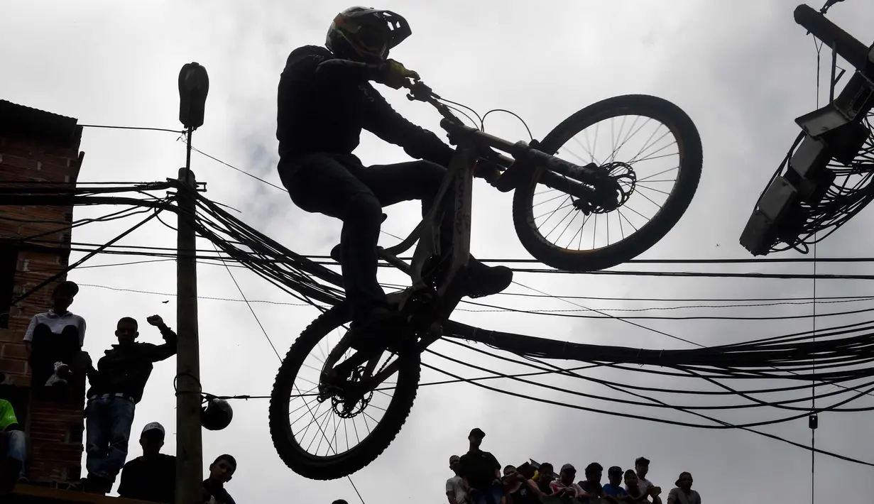Aksi peserta lomba sepeda saat mengikuti balapan Urban Bike Inder Medellin di gubuk comuna 1 di Medellin, Antioquia department, Kolombia (19/11). (AFP Photo/Joaquin Sarmiento)