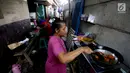 Warga memasak di kawasanan pemukiman kumuh di kolong Tol Pluit, Jakarta, Kamis (14/12). Kolong Tol Pluit ini menjadi pemukiman bagi warga berpenghasilan rendah. (Liputan6.com/JohanTallo)