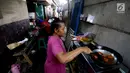 Warga memasak di kawasanan pemukiman kumuh di kolong Tol Pluit, Jakarta, Kamis (14/12). Kolong Tol Pluit ini menjadi pemukiman bagi warga berpenghasilan rendah. (Liputan6.com/JohanTallo)