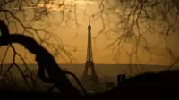 Pemandangan Menara Eiffel yang diselimuti kabut polusi, Paris, Prancis (3/12). Kondisi berkabut ini terjadi karena dinginnya udara malam dan hangatnya suhu siang hari, sehingga polusi kendaraan terperangkap dan sulit hilang. (AFP/Lionel Bonaventure)