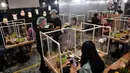 Pengunjung makan di sela-sela pembatas plastik untuk mencegah penyebaran virus corona di restoran hotpot Penguin Eat Shabu di Bangkok, 5 Mei 2020. Restoran kembali dibuka setelah Thailand memperlonggar lockdown dengan mengizinkan tempat makan menerapkan social distancing. (Lillian SUWANRUMPHA/AFP)