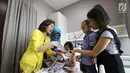 Karyawan dengan baju kebaya memberikan setangkai bunga dan buku kreativitas Kartini kepada pasien anak saat peringati Hari Kartini di RS Siloam TB Simatupang, Jakarta, Sabtu (21/4). (Liputan6.com/Fery Pradolo)