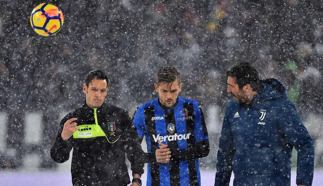 Wasit Maurizio Mariani (kiri) berbincang dengan pemain Atalanta, Rafael Toloi (tengah) dan kiper Juventus Gianluigi Buffon di lapangan Allianz Stadium yang diselimuti salju tebal di Turin, Italia, (25/2). (Alessandro Di Marco / ANSA via AP)