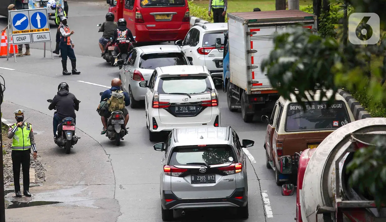 Sejumlah petugas mengatur lalu lintas saat uji coba ganjil-genap di Jalan Margonda Raya, Depok, Jawa Barat, Minggu (5/12/2021). Polres Metro Kota Depok bersama Dishub menyiapkan enam pos pemeriksaan dalam melaksanakan uji coba penerapan ganjil-genap (gage). (Liputan6.com/Herman Zakharia)