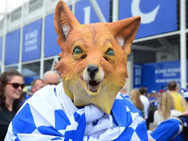 Seorang fans Leicester City mengenakan topeng maskot kebanggan Leicester City saat merayakan titel juara Liga Inggris 2015-2016 di Areal Stadion King Power (7/5/2016). (AFP/Glyn Kirk)