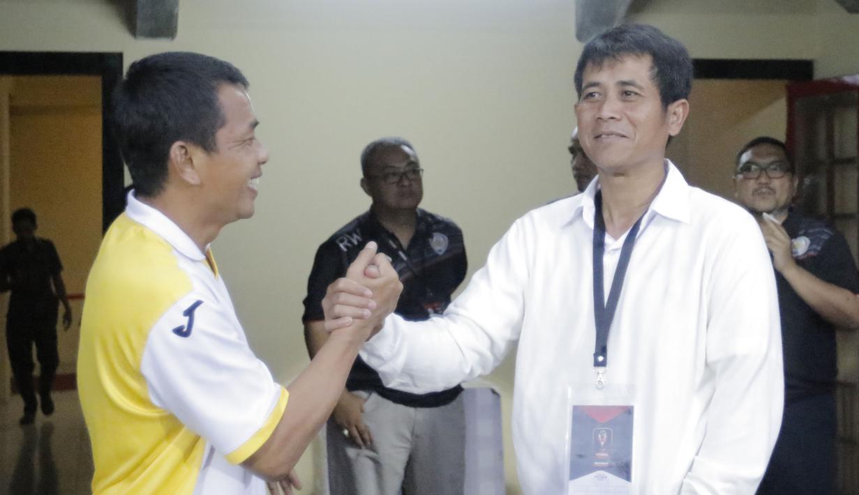 Sebelum pertandingan, pelatih Mitra Kukar, Jafri Sastra, dan pelatih Arema Cronus, Joko Susilo, berbincang akrab. (Bola.com/Erwin Fitriansyah)