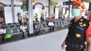 Petugas gabungan dari Polrestabes Semarang menyemprot larutan disinfektan kepada penumpang yang turun di Stasiun KA Tawang, Sabtu (28/3/2020). Selain sterilisasi, petugas juga melakukan pencatatan penumpang yang turun untuk data pengawasan guna menekan penularan Corona COVID-19. (Liputan6.com/Gholib