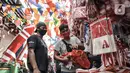 Pedagang melayani pembeli pernak-pernik Hari Kemerdekaan di Pasar Jatinegara, Jakarta, Minggu (2/8/2020). Menjelang perayaan HUT ke-75 Republik Indonesia, Pasar Jatinegara mulai dipadati warga yang ingin mencari beragam pernak-pernik hiasan kemerdekaan. (merdeka.com/Iqbal Nugroho)