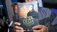 Warga menunjukkan kenang-kenangan buku Yassin seusai acara tahlilan 40 hari meninggalnya Olga Syhaputra di kediaman orang tua Olga di kawasan Duren Sawit, Jakarta, Rabu (6/5/2015). (Liputan6.com/Panji Diksana)