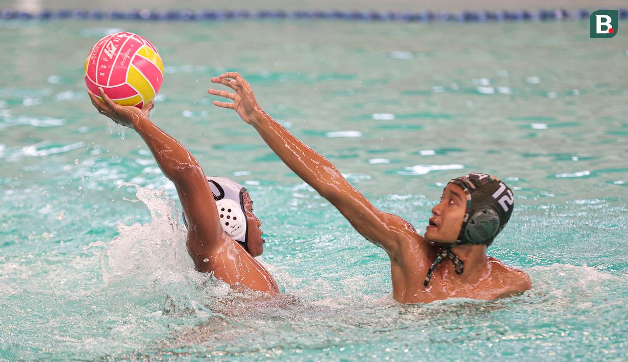 Pemain Pari Sakti (kiri) mencoba mempertahankan bola pada partai final polo air kategori U-14 Indonesia Open Aquatic Championships (IOAC) 2025 di Stadion Akuatik GBK, Jakarta Pusat, pada Kamis (13/11/2025). (Bola.com/Abdul Aziz)