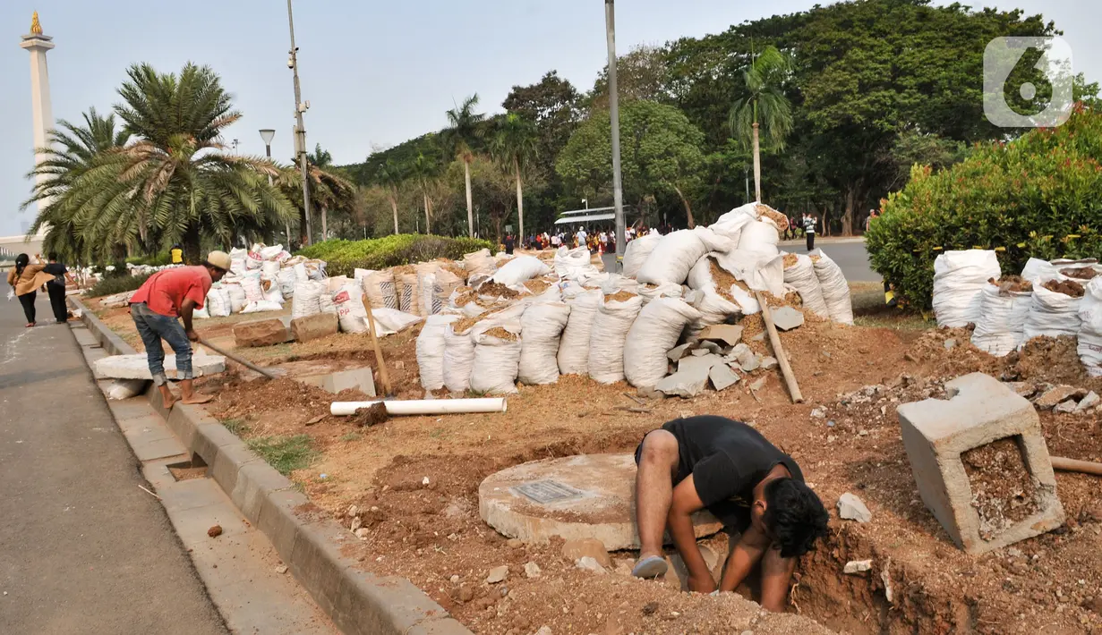 Pekerja menyelesaikan pembuatan sumur resapan di kawasan Monas, Kamis (21/11/2019). Sudin Perindustrian dan Energi Kota Administrasi Jakpus membuat sekitar 70 titik sumur resapan di taman kawasan Monas guna meminimalisir genangan sekaligus menampung air saat hujan. (merdeka.com/Iqbal Nugroho)