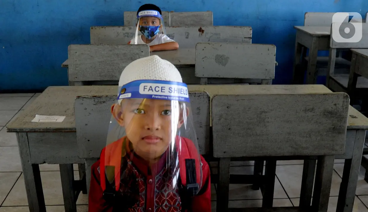 Calon siswa dengan menggunakan face shield menunggu untuk psikotes di SD Islam Al-Hidayah, Cinere, Depok, Senin (6/7/2020). Tes psikologi itu sebagai syarat kesiapan masuk jenjang pendidikan sekolah dasar jelang pelaksanaan tahun ajaran baru 2020/2021 pada 13 Juli mendatang. (merdeka.com/Arie Basuki