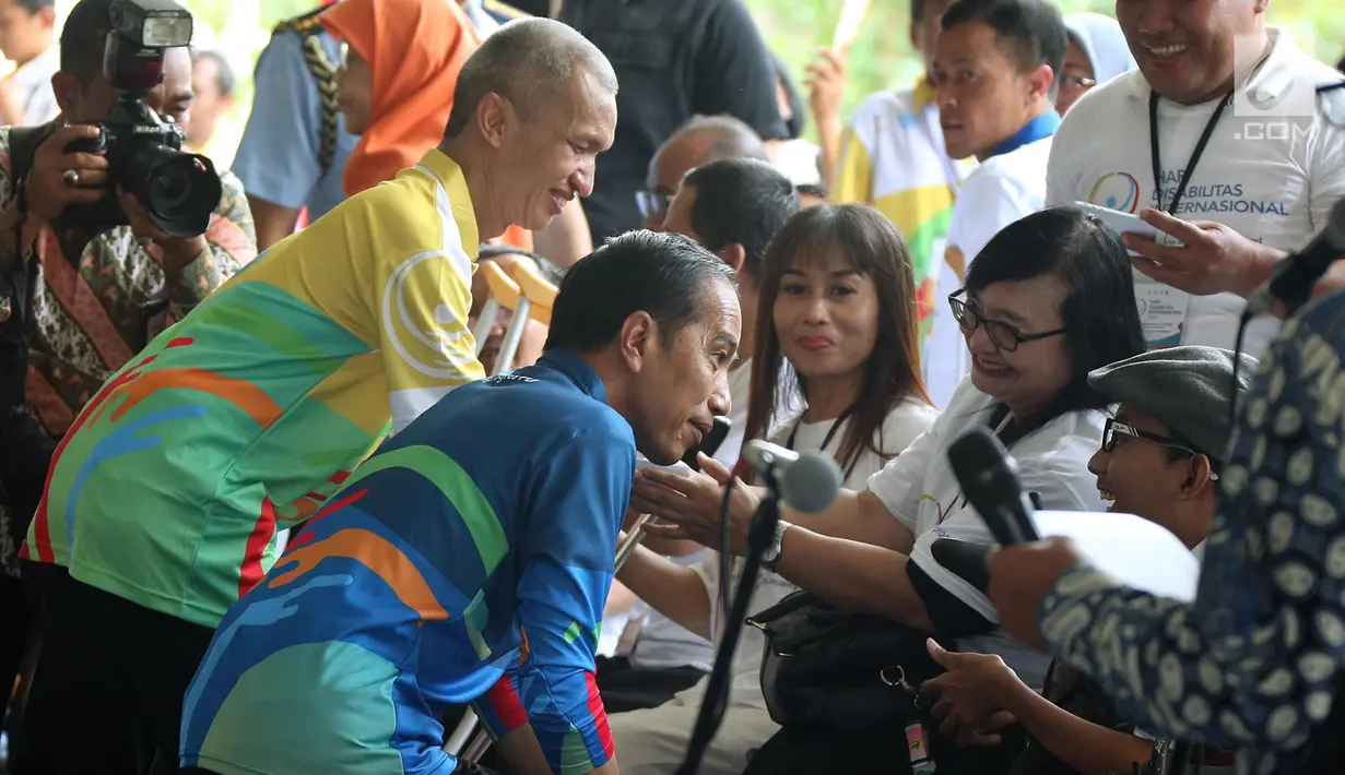 Presiden Joko Widodo berbincang dengan penyandang disabilitas saat peringatan Hari Disabilitas Internasional 2018 di Bekasi, Senin (3/12). Jokowi berharap pembangunan pabrik untuk penyandang disabilitas memberi ruang berkarya. (Liputan6 com/Angga Yuniar)
