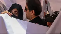 Mantan perdana menteri Pakistan Imran Khan (tengah) bersama istrinya Bushra Bibi (kiri). (AFP)