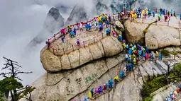 Foto dari udara yang diabadikan pada 20 September 2020 ini menunjukkan para wisatawan yang berjalan di atas Gunung Huashan yang diselimuti kabut di Kota Weinan, Provinsi Shaanxi, China barat laut. (Xinhua/Tao Ming)