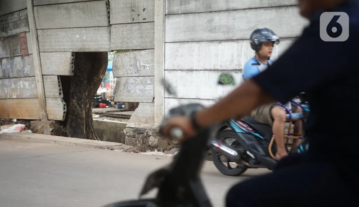 Tembok berlubang terlihat di Terminal Kampung Rambutan, Jakarta, Kamis (19/12/2019). Jauhnya akses bagi pejalan kaki menjadikan tembok berlubang tersebut pintu alternatif untuk keluar dan masuk Terminal Kampung Rambutan. (Liputan6.com/Immanuel Antonius)