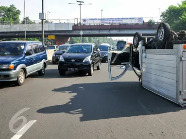 Sebuah mobil boks terbalik di KM 02 Tol Cawang arah Cililitan, Jakarta, Senin (30/5). Mobil boks bernomor polisi B 9385 HH itu terbalik tepat di tengah jalan di lajur samping Gerbang Tol Cilitan arah ke Taman Mini. (Liputan6.com/Yoppy Renato)