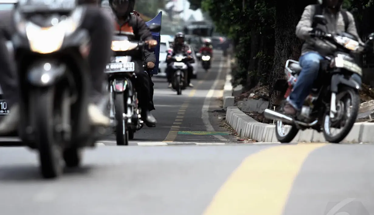 Minimnya jalur khusus sepeda yang tersedia di Jakarta membuat para pengguna sepeda harus berebut jalan dengan kendaraan bermotor. Foto diambil pada Kamis (4/12/2014). (Liputan6.com/Faizal Fanani)