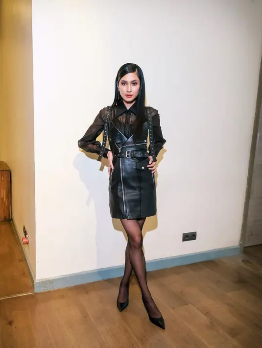 Mikha Tambayong menghadirkan tampilan glam rock yang memesona. Ia memadukan inner sheer lengan panjang dengan dress kulit yang sama-sama berwarna hitam. [Foto: Instagram/miktambayong]