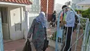 Warga membawa makanan berbuka puasa gratis dari relawan selama bulan suci Ramadan di Ariana, Tunisia (7/5/2020). Masjid-masjid di Aljazair, Maroko dan Tunisia telah ditutup untuk membatasi penyebaran Covid-19, mencegah doa malam khusus. (AFP/Fethi Belad)