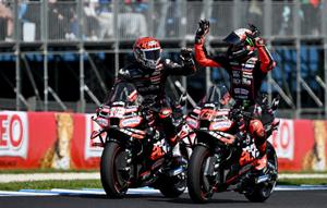 Pembalap MotoGP Italia dari tim Aprilia Racing, Marco Bezzecchi (kanan), merayakan kemenangannya dalam sprint race MotoGP Grand Prix Australia bersama rekan setim sekaligus rekan senegaranya, Lorenzo Savadori, di Phillip Island pada 18 Oktober 2025. (Paul CROCK/AFP)