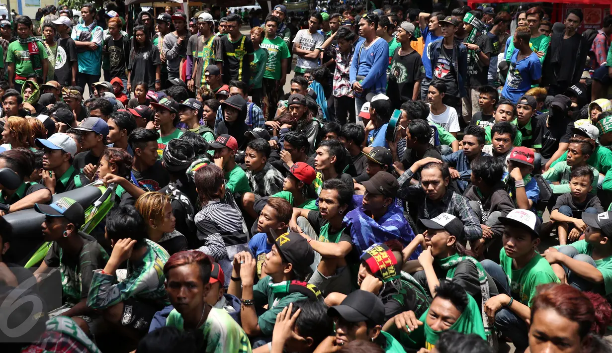 Ratusan suporter klub Persebaya duduk antri mengambil makanan di kawasan GOR Padjajaran, Bandung, Sabtu (7/1). Seiring pelaksanaan kongres PSSI 2017, pendukung Persebaya Surabaya berkumpul di GOR Padjajaran, Bandung. (Liputan6.com/Helmi Fithriansyah)