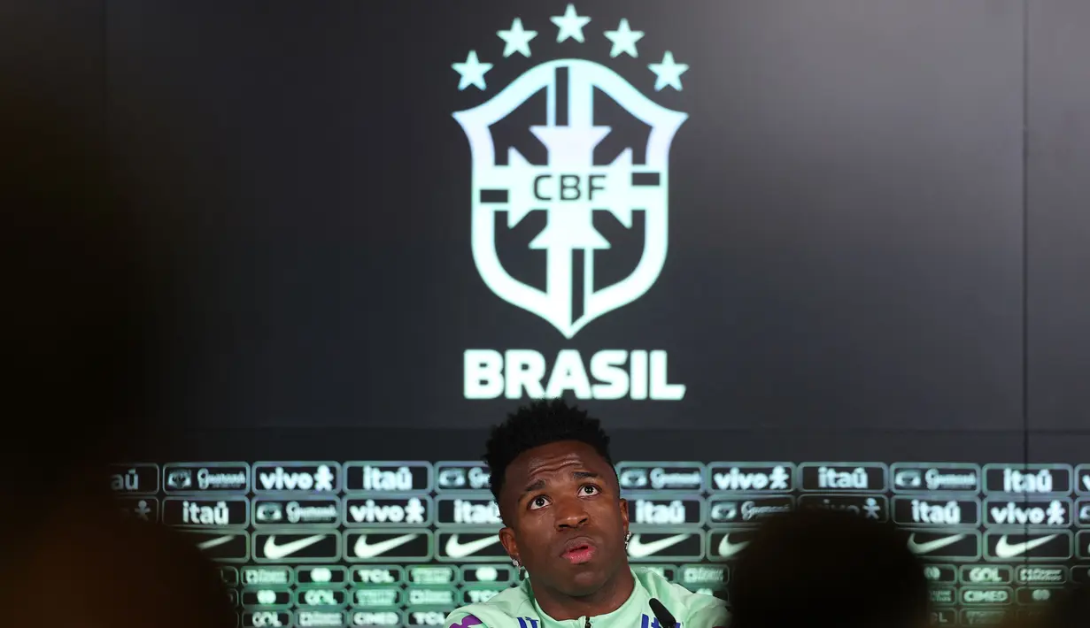 Pemain Brasil, Vinicius Jr saat konferensi pers menjelang laga persahabatan melawan Spanyol di tempat latihan Ciudad Real Madrid di Valdebebas, pinggiran Madrid, pada 25 Maret 2024. Laga tersebut memiliki slogan "Satu Kulit" untuk membantu memerangi rasisme. (AFP/Pierre-Philippe Marcou)