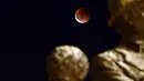 Gerhana bulan kali ini memberikan pemandangan terbaik di wilayah Asia dan Australia bagian barat. Tampak dalam foto, Gerhana Bulan Total yang disertai dengan fenomena Bulan Darah terlihat di atas monumen Gemidzhii di Skopje, Makedonia Utara pada 8 September 2025. (Robert ATANASOVSKI/AFP)