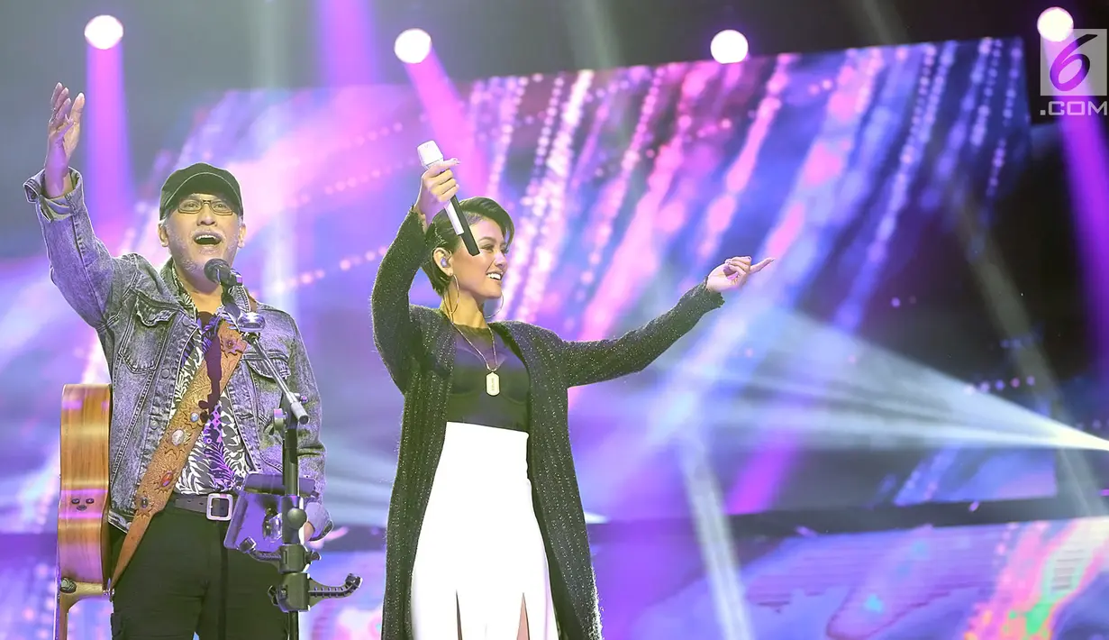 Penyanyi Iwan Fals dan Agnes Monica alias Agnez Mo menyapa penonton saat Konser Raya 24 Tahun Indosiar Luar Biasa di JCC Senayan, Jakarta, Jumat (11/1). Iwan Fals dan Agnez Mo menampilkan kolaborasi apik lewat duet mereka. (Fimela.com/Bambang Eros)
