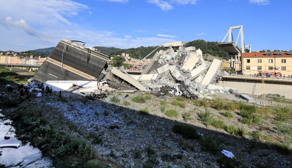 Puing-puing dari jembatan jalan raya Morandi yang ambruk di kota Genoa, Italia, Selasa (14/8). Saat ini, anjing pelacak turut dikerahkan untuk mencari korban dan alat berat diturunkan untuk mengangkat reruntuhan. (Valery HACHE / AFP)