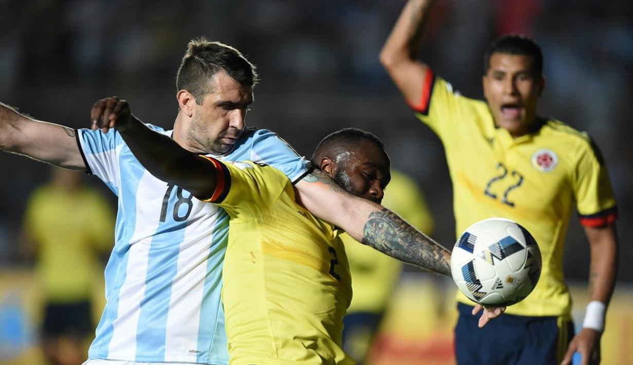 Pemain Argentina, Lucas Pratto (kiri), berebut bola dengan pemain Kolombia, Eder Alvarez, pada laga kualifikasi Piala Dunia 2018 zona CONMEBOL di Estadio San Juan del Bicentenario, Selasa (15/11/2016). (AFP/Eitan Abramovich)