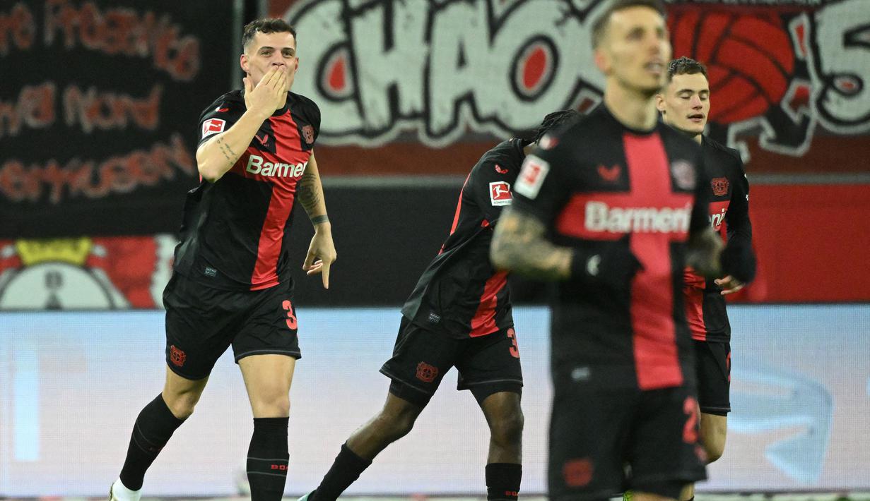 Gelandang bertahan Swiss berusia 31 tahun, Granit Xhaka didatangkan Bayer Leverkusen dari Arsenal dengan nilai transfer 15 juta euro dengan durasi kontrak selama 5 tahun hingga akhir musim 2027/2028. Telah bermain dalam 31 laga di semua kompetisi, ia telah mencetak 1 gol dan 1 assist. Gol tersebut baru saja dicetaknya pada laga pekan ke-23 Bundesliga 2023/2024 (23/2/2024) yang ikut membawa kemenangan 2-1 atas FSV Mainz. (AFP/Ina Fassbender)