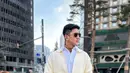 Ia juga mengenakan turtleneck coklat dipadukan kemeja putih dan jaket soft kuning. Serta bawahan celana coklat panjang. [@bramastavrl]