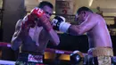 Ilham Leoisa (kiri) dan Paiboon Lorkham saling melepaskan pukulan  pada kelas Super-Lightweight Mahkota Boxing Super Series di Cilandak Town Square, Jakarta (10/3/2018). Ilham menang angka mutlak. (Bola.com/Nick Hanoatubun)