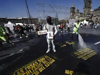 Pedro Cortes dari negara bagian Oaxaca memegang foto putrinya Belen Cortes (14 tahun) yang menghilang pada 1 Desember dari Zocalo saat dia bergabung dengan protes menuntut jawaban dari pemerintah tentang orang-orang yang hilang di Mexico City, Meksiko, 13 Desember 2021. (AP Photo/Marco Ugarte)