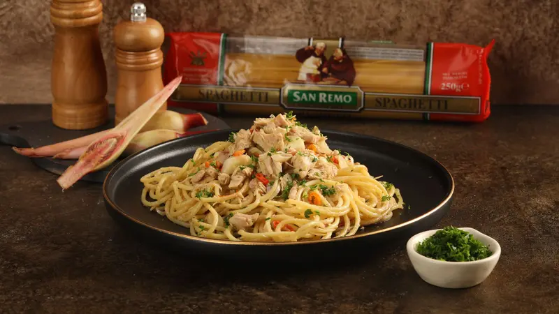 Hidangan spaghetti tuna segar dengan potongan tuna, tomat ceri, dan peterseli yang memberikan rasa gurih dan segar