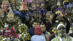 Warga membeli lentera tradisional jelang bulan suci Ramadhan di sebuah toko di Distrik Sayyida Zeinab, Kairo, Mesir, 30 Maret 2022. Umat muslim Mesir memperketat dompet mereka jelang Ramadhan saat pengeluaran meningkat karena mata uang lokal kehilangan 17 persen nilainya. (Khaled DESOUKI/AFP)