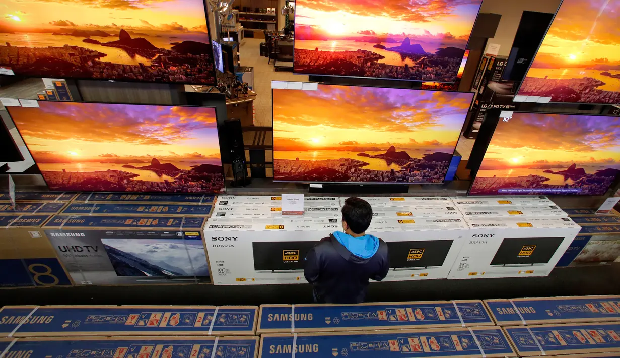 Seorang pria melihat televisi selama perayaan Black Friday di toko Best Buy di Overland Park, Kansas, AS (22/11). Black Friday merupakan pesta diskon besar-besaran yang digelar menjelang Hari Natal. (AP Photo/Charlie Riedel)