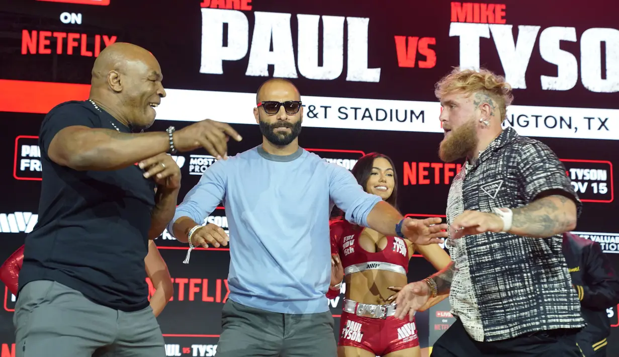Aksi Mike Tyson ini tampak membuat Jake Paul geram, meski diketahui hanya sekadar candaan. Jake Paul pun kemudian gantian mendorong Mike Tyson. Tetapi, Mike Tyson menanggapinya dengan tertawa. (AFP/Timothy A. Clary)