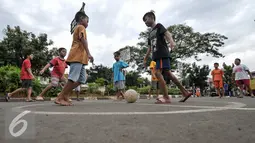 Sejumlah anak bermain sepak bola di Jalan Tambak, Manggarai, Jakarta, Jumat (22/7). Masih kurangnya taman bermain di Jakarta, membuat warga khususnya anak-anak memanfaatkan fasilitas yang bukan peruntukannya. (Liputan6.com/Yoppy Renato)
