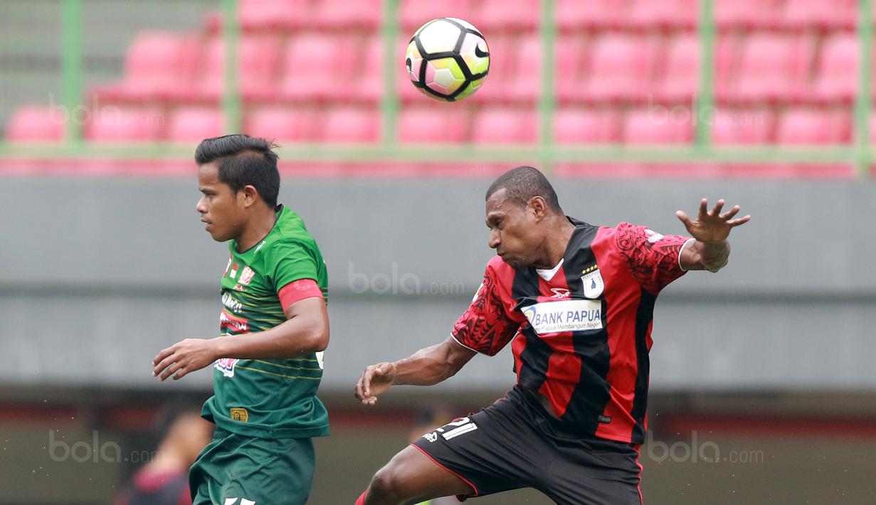 Duel udara pemain Persipura Jayapura, Yustinus Pae (kanan) dan pemain PS TNI, Manahati Lestusen  pada lanjutan Liga 1 2017 di Stadion Patriot, Bekasi (4/11/2017). PS TNI menang 2-1. (Bola.com/Nick Hanoatubun)