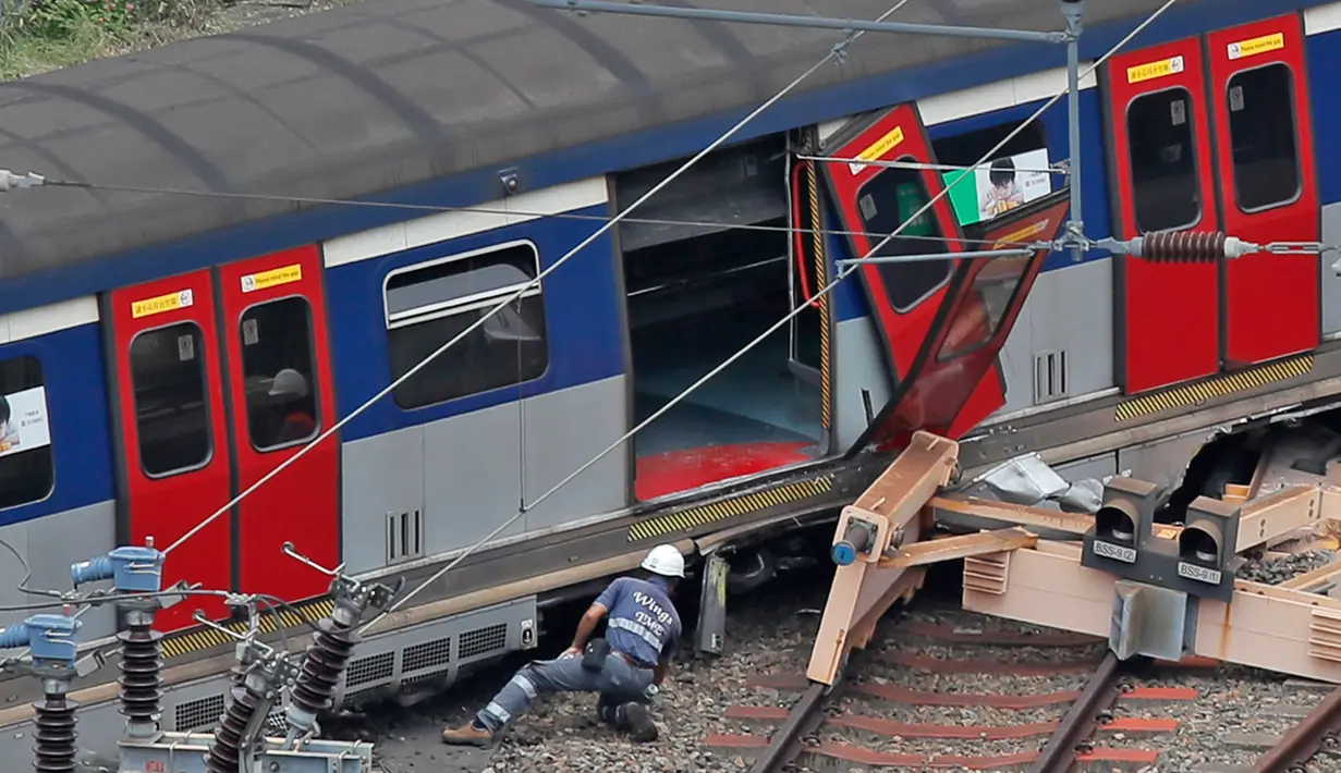 Regu penyelamat berada di lokasi tergelincirnya kereta metro atau Mass Transit Railway (MTR) di Stasiun Hung Hom, Hong Kong, Selasa (17/9/2019). Para penumpang terpaksa keluar dari kereta dengan membuka paksa pintu lalu menyeberangi rel jalur East Rail. (AP Photo/Kin Cheung)