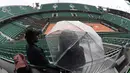 Penonton menanti hujan reda untuk menyaksikan turnamen   Prancis Terbuka 2016 di Roland Garros (28/5/2016).(AFP/Miguel Medina)
