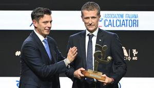 Wasit Italia, Daniele Orsato, berpose di atas panggung setelah menerima penghargaan 'Wasit Terbaik' dari Gianluca Rocchi (kiri) selama acara penghargaan Italian Footballers' Association (AIC) 2023 pada 4 Desember 2023 di Milan. (Marco BERTORELLO/AFP)