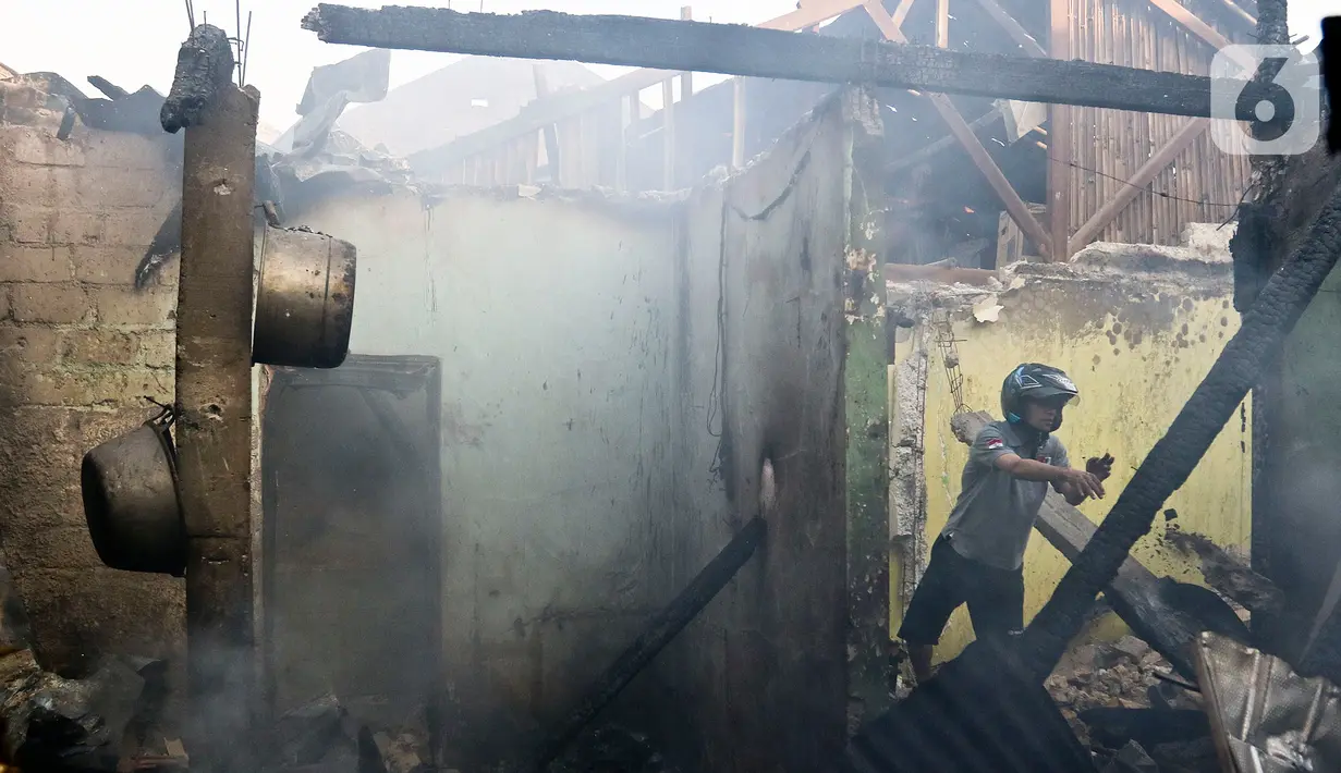 Warga membantu petugas pemadam kebakaran melakukan pendinginan usai kebakaran melanda pemukiman padat penduduk di kawasan Peninggaran Timur, Kebayoran Lama, Jakarta, Senin (27/1/2019). Kebakaran menewaskan satu orang pria akibat terjebak dalam kamar. (Liputan6.com/Johan Tallo)